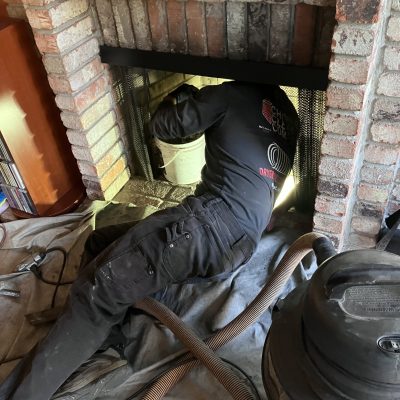 chimney clean company technician cleaning the chimney